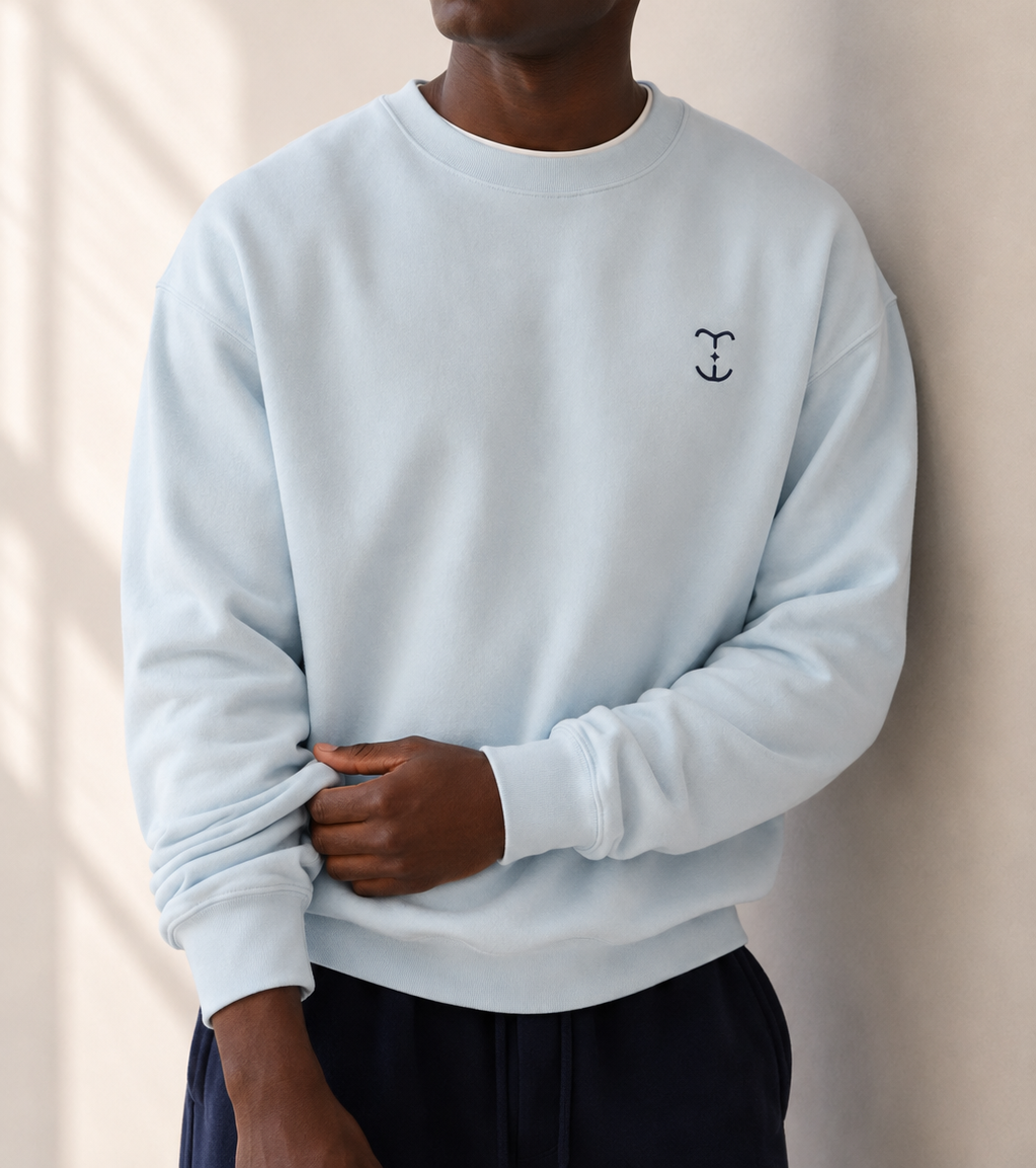 Model wearing a TELLS baby blue sweatshirt styled as a soft autumn colour