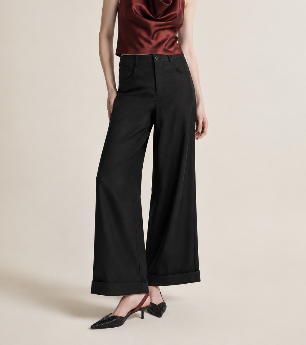 Woman wearing flowing black wide-leg trousers for a refined occasion look