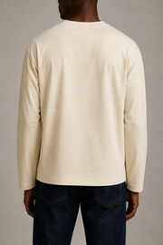Rear studio view of the TELLS Signature Sunfade Long Sleeve in Apricot, showing the plain back, dropped shoulders and straight hem with dark indigo jeans.