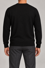 Rear studio view of Still Hours Crewneck Sweater in Black, showing its unadorned back and ribbed hem.