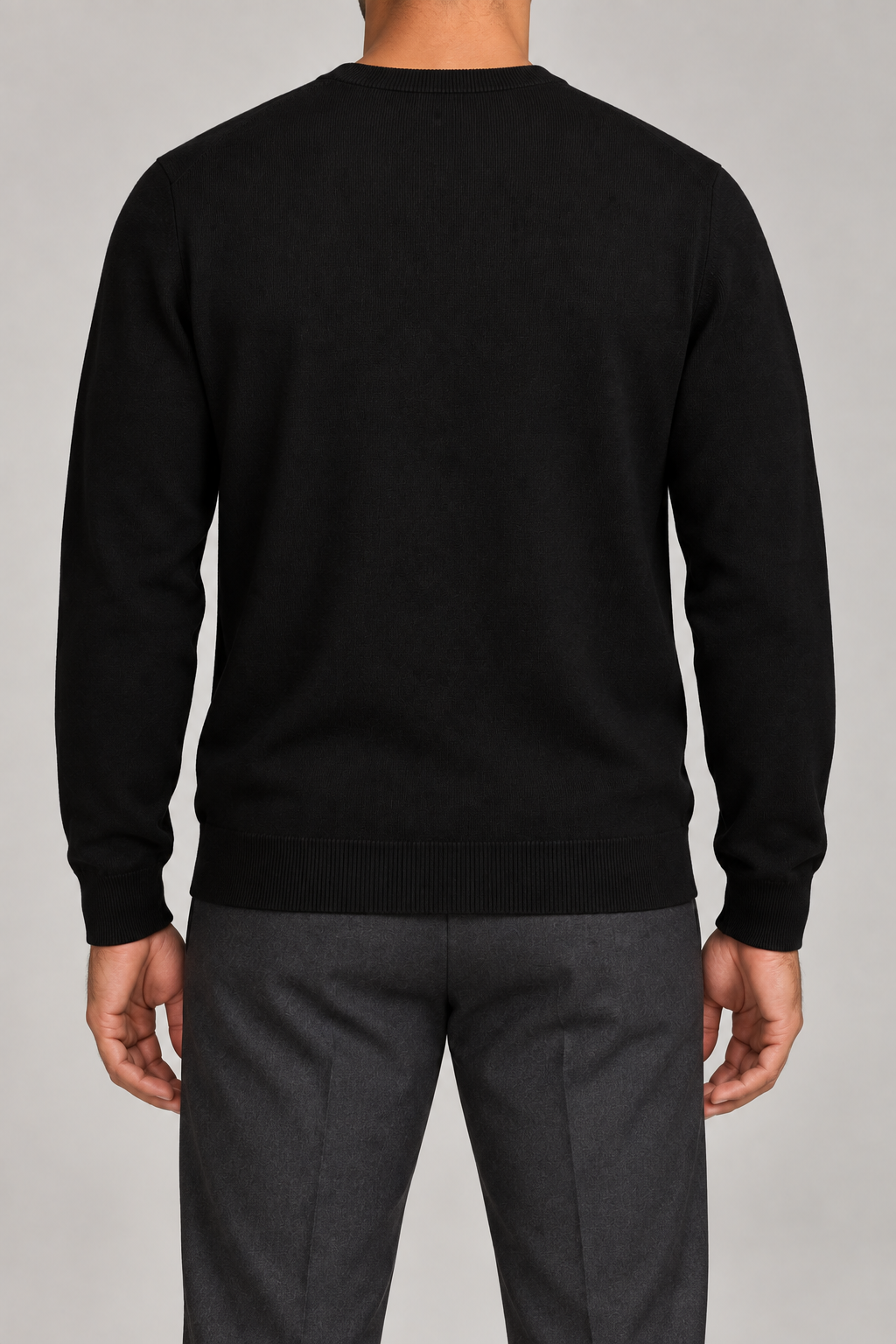 Rear studio view of Still Hours Crewneck Sweater in Black, showing its unadorned back and ribbed hem.