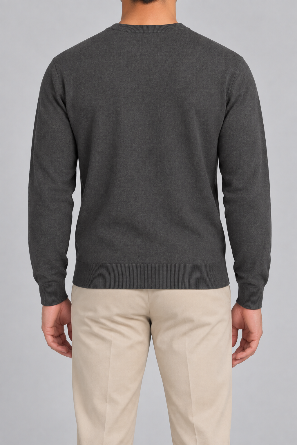Rear studio view of Still Hours Crewneck Sweater in Charcoal, showing the unadorned back and long sleeves.