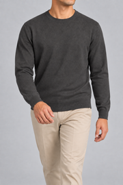 Walking studio view of Still Hours Crewneck Sweater in Charcoal, showing the natural drape of the plain knit.