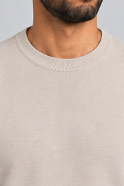 Neckline close-up of Still Hours Crewneck Sweater in Sand, showing the fine Sand knit texture and ribbed collar.