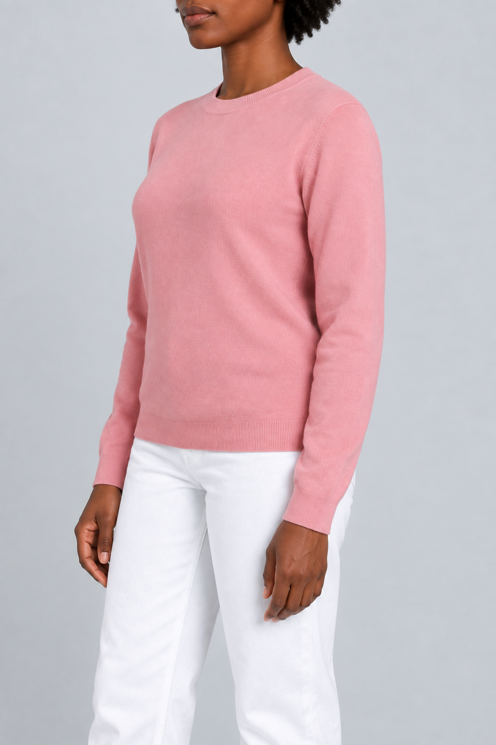 Three-quarter studio view of Quiet Form Crewneck Sweater in Pink, showing the long sleeves and classic silhouette.