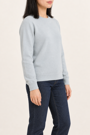 Three-quarter studio view of Quiet Form Crewneck Sweater in Powder, showing the long sleeves and classic silhouette.