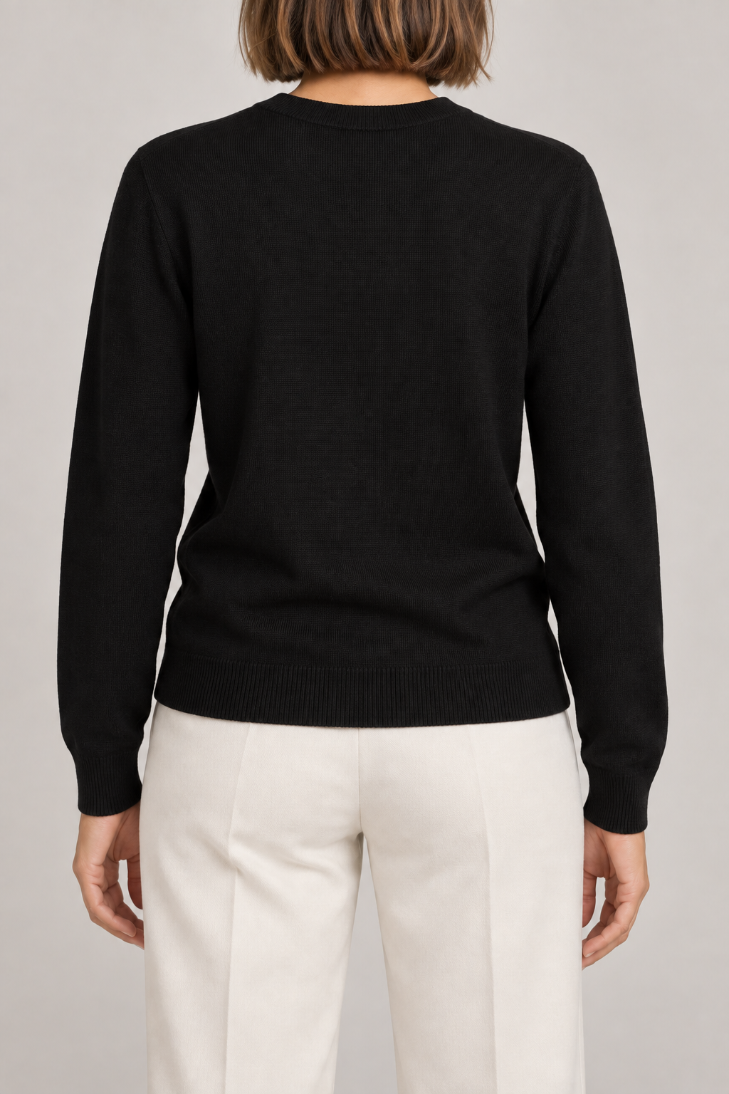 Rear studio view of Quiet Form Crewneck Sweater in Black, showing the plain back and ribbed hem.