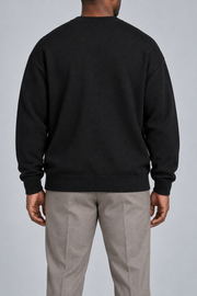 Rear studio view of Slow Days Relaxed Crewneck in Black, showing the plain back and ribbed hem.