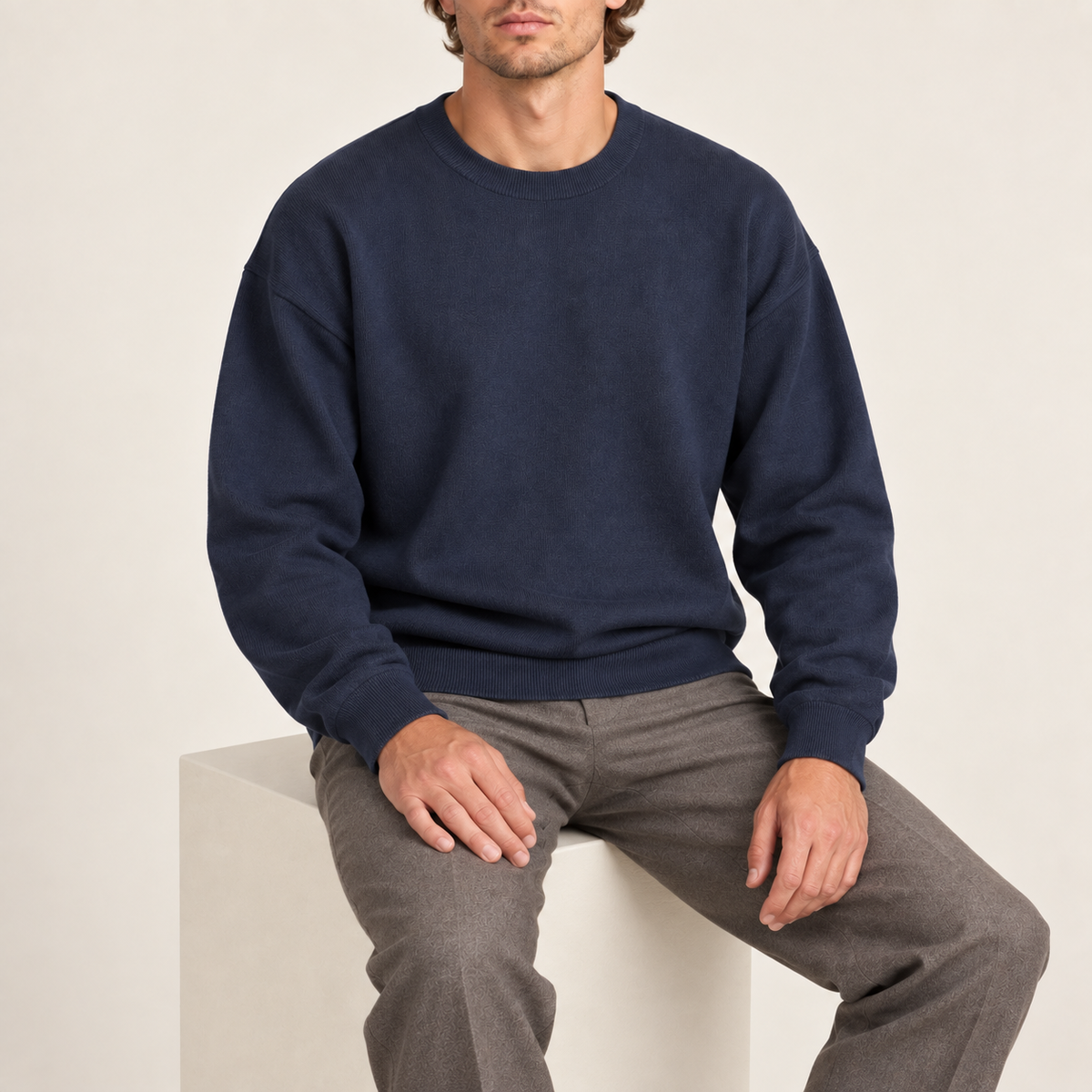 Seated studio view of Slow Days Relaxed Crewneck in Navy, showing the natural knit drape.