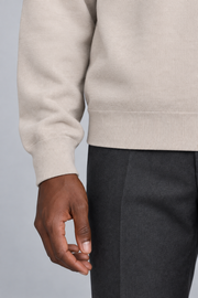 Slow Days Relaxed Crewneck in Sand. Close-up of the Sand knit cuff and hem beside charcoal trousers.