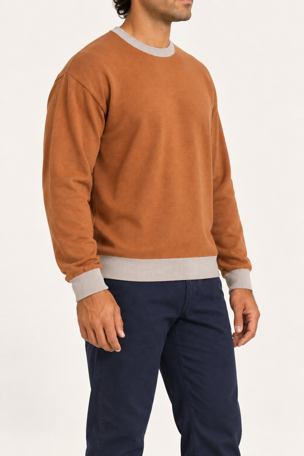 Slow Days Relaxed Crewneck in Rust with Coco Trim. Three-quarter view showing the relaxed shape and Coco cuffs and hem.