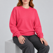 Soft Pause Relaxed Crewneck in Hot Pink. Seated view showing the relaxed Hot Pink knit drape.