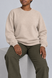Soft Pause Relaxed Crewneck in Taupe. Seated view showing the relaxed Taupe knit drape.