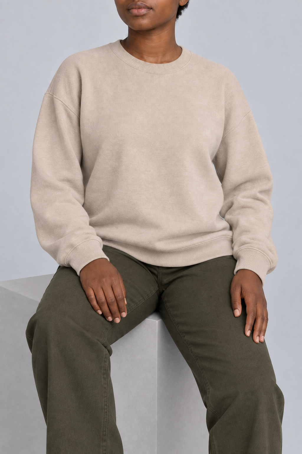 Soft Pause Relaxed Crewneck in Taupe. Seated view showing the relaxed Taupe knit drape.