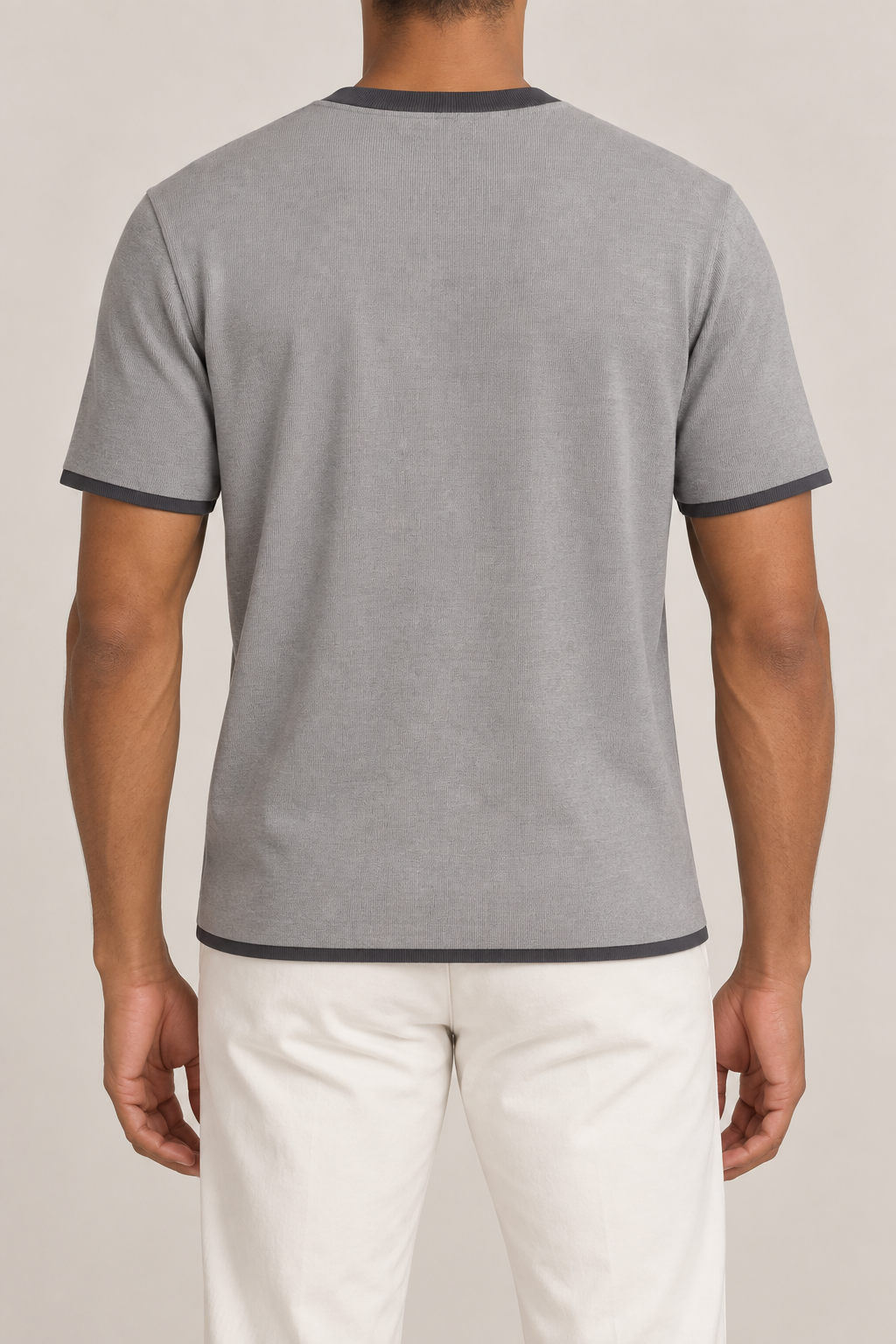 Rear studio view of Open Hours Knit T-Shirt in Grey with Charcoal Trim, showing plain grey back with dark hem and sleeve edges.