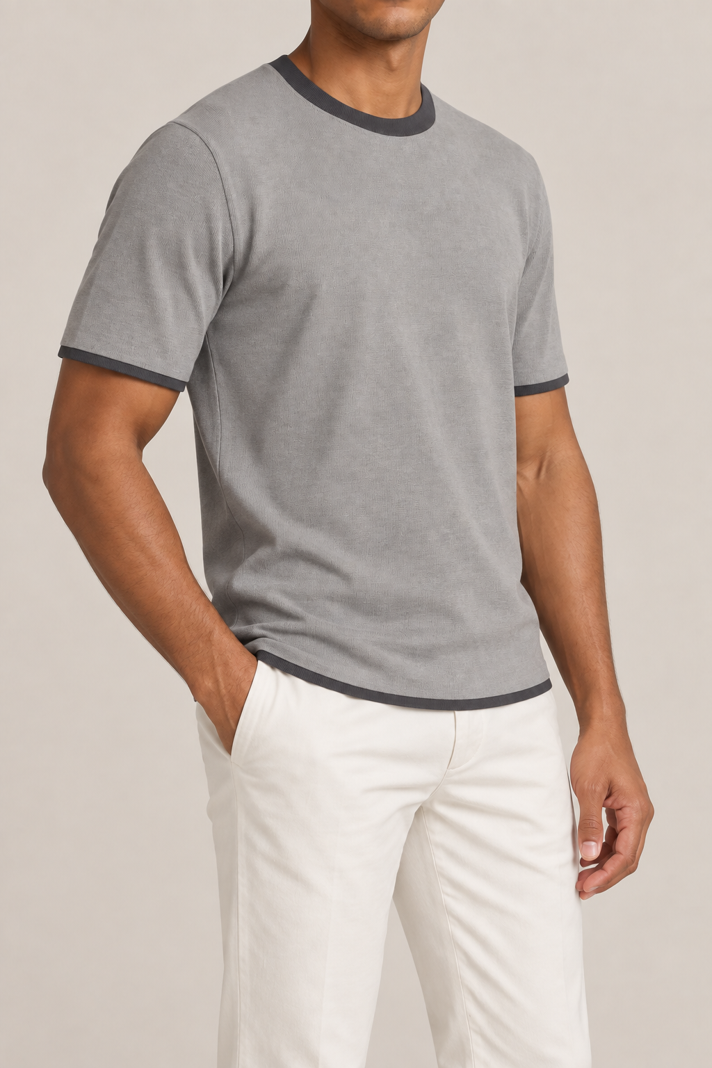 Three-quarter studio view of Open Hours Knit T-Shirt in Grey with Charcoal Trim, showing short sleeves and contrasting charcoal edges.