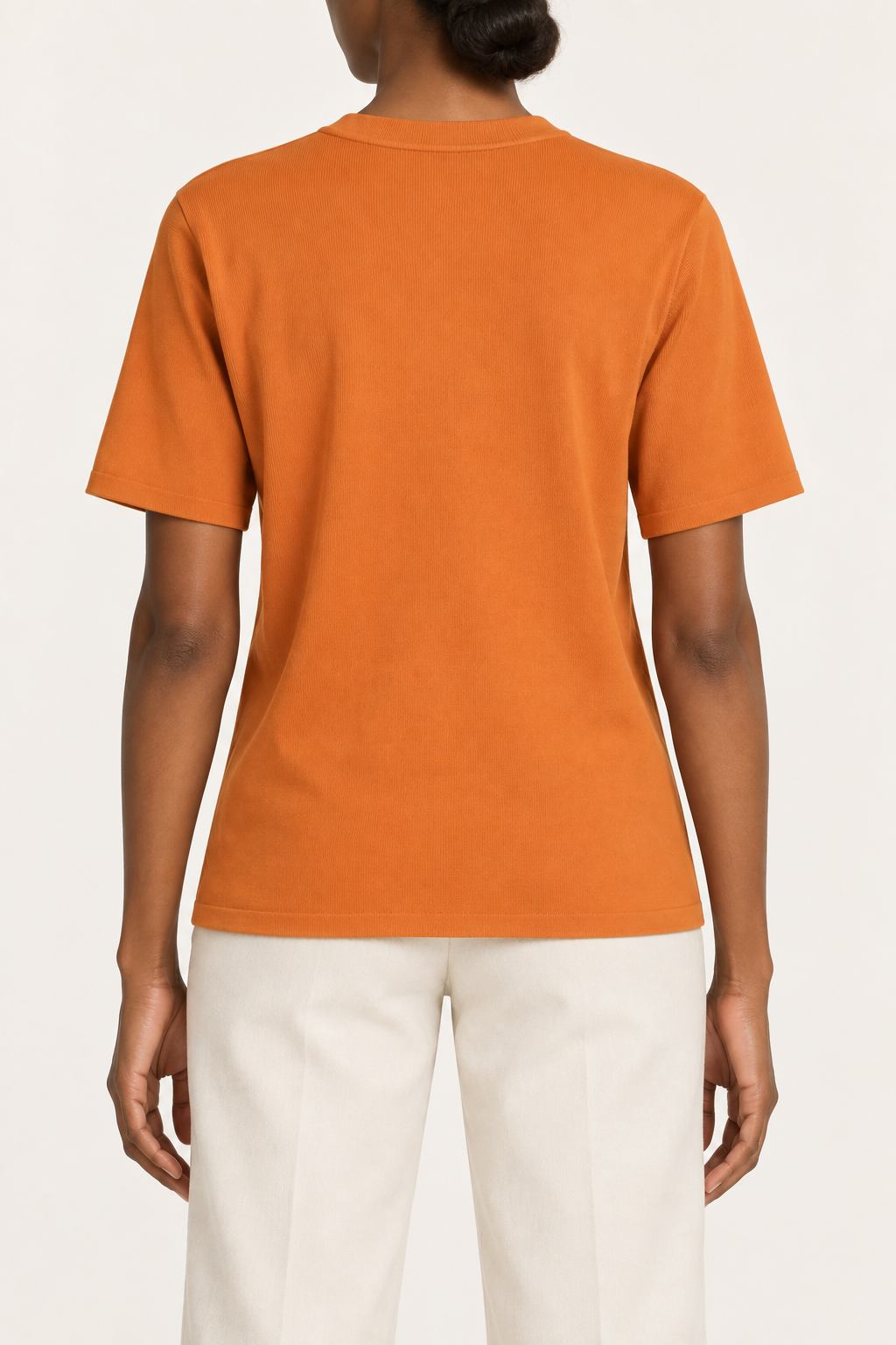 Rear studio view of Soft Tempo Knit T-Shirt in Orange, showing plain orange back and short sleeves.