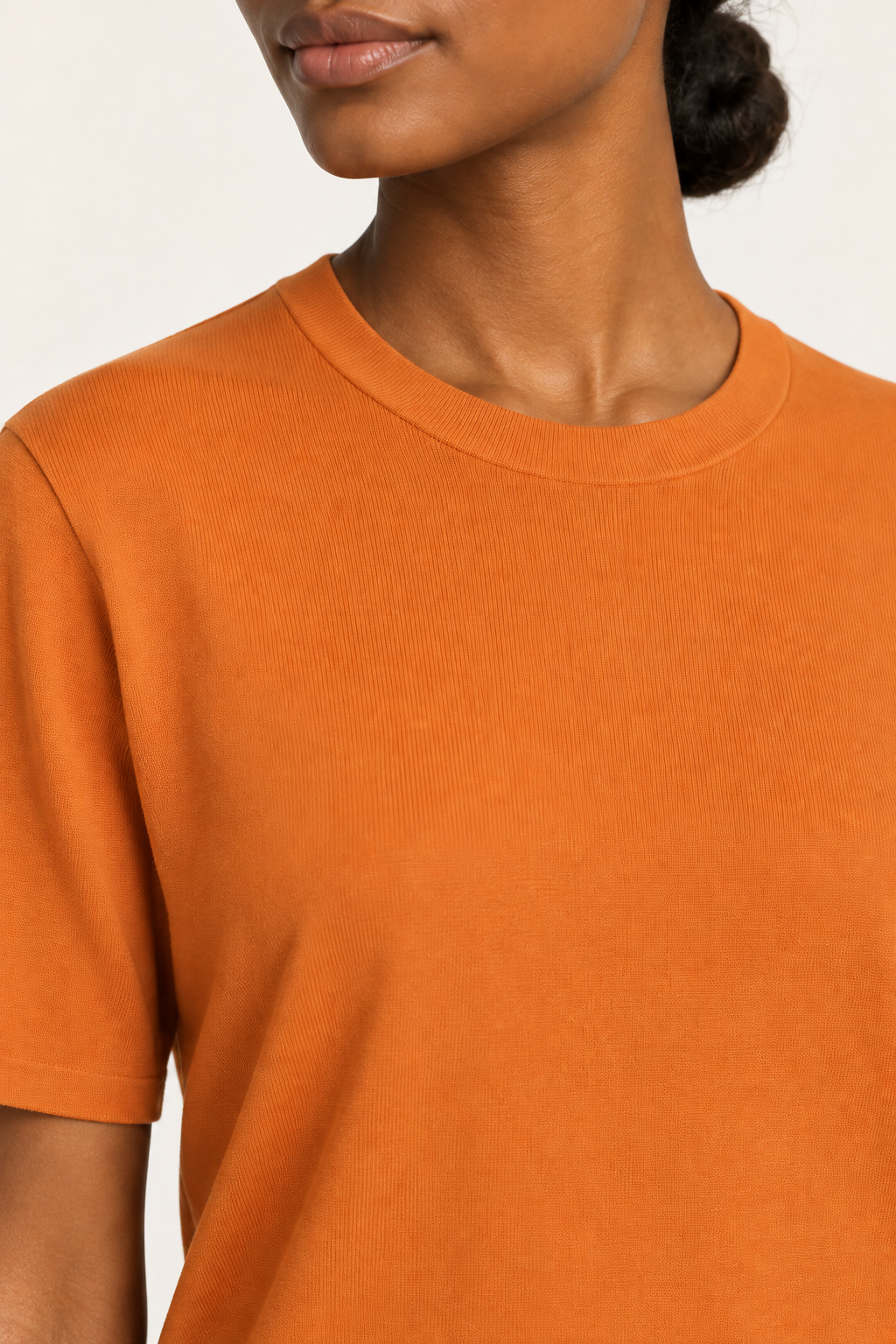 Close-up detail of Soft Tempo Knit T-Shirt in Orange, showing orange knit texture and matching neck band.