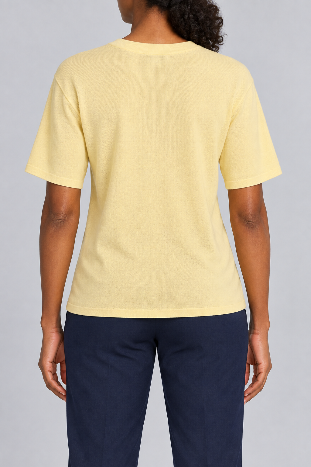 Rear studio view of Soft Tempo Knit T-Shirt in Mellow, showing plain yellow back and short sleeves.