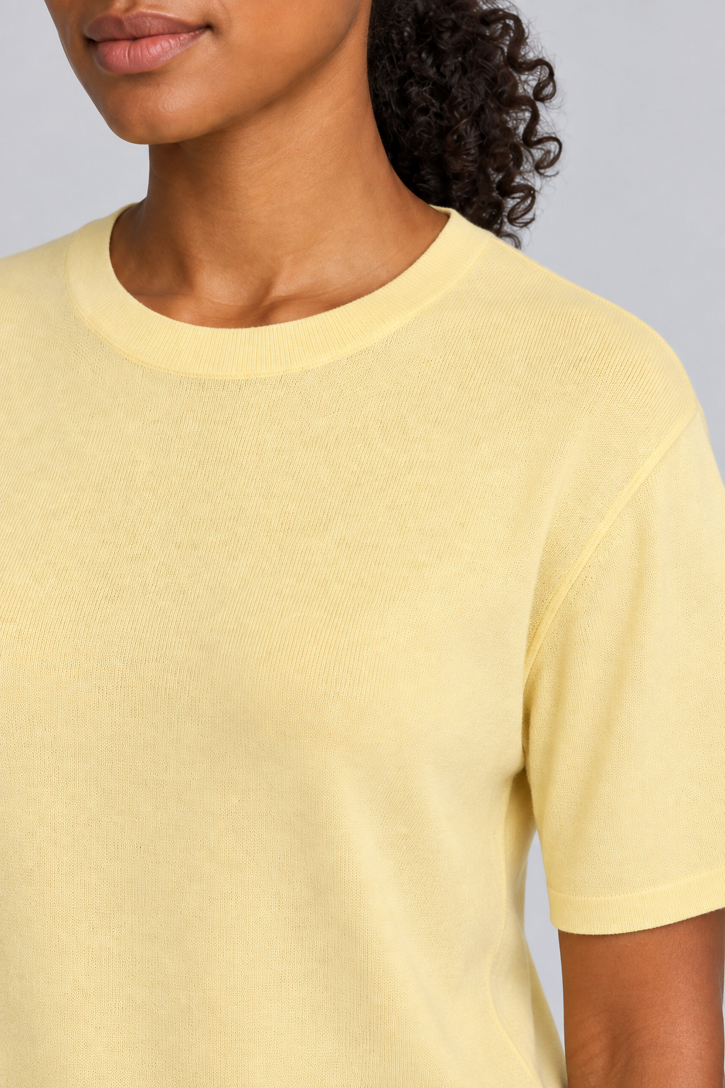 Close-up detail of Soft Tempo Knit T-Shirt in Mellow, showing pale yellow knit texture and matching neck band.