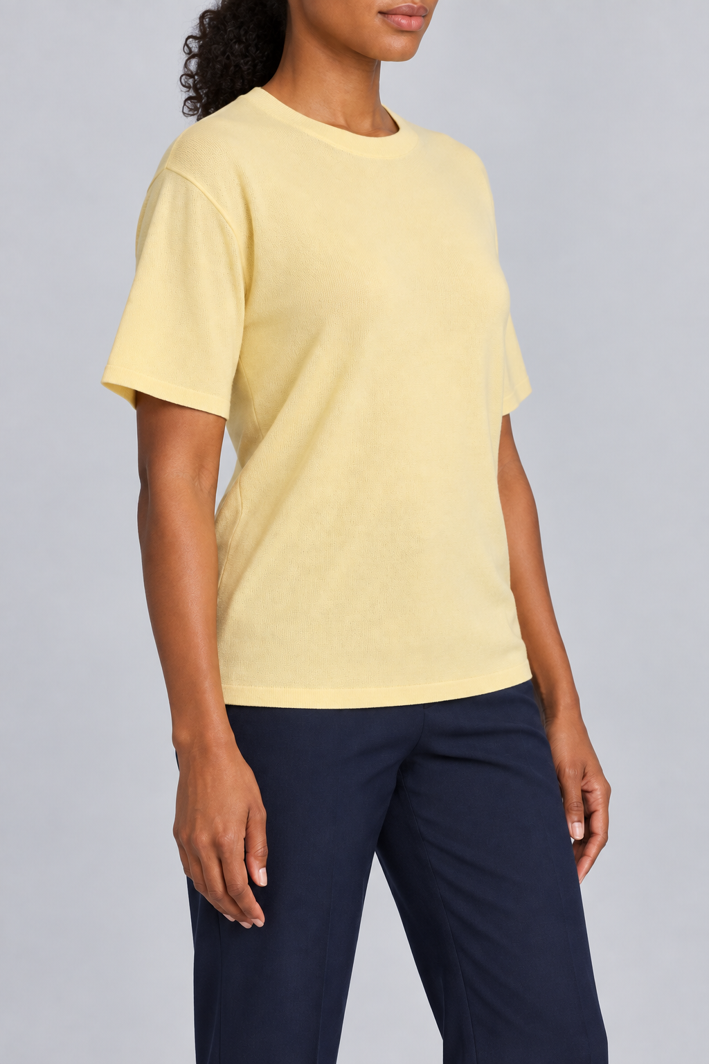 Three-quarter studio view of Soft Tempo Knit T-Shirt in Mellow, showing short sleeves and clean yellow silhouette.