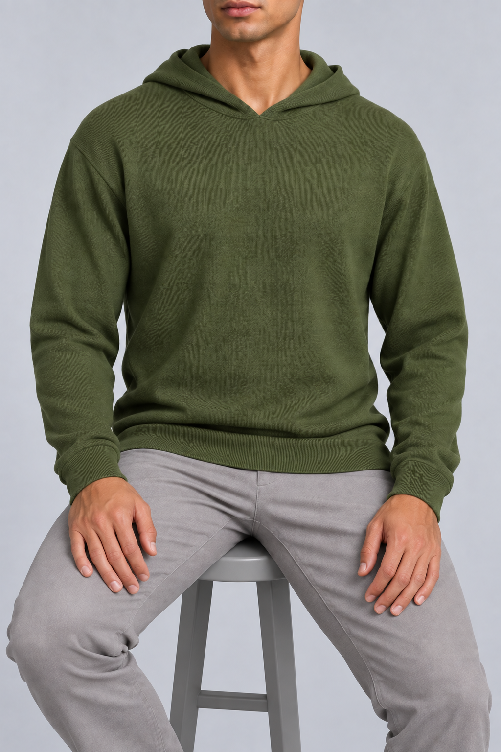 Seated view showing the soft knit drape and long sleeves of Off Hours Knit Hoodie in Olive.
