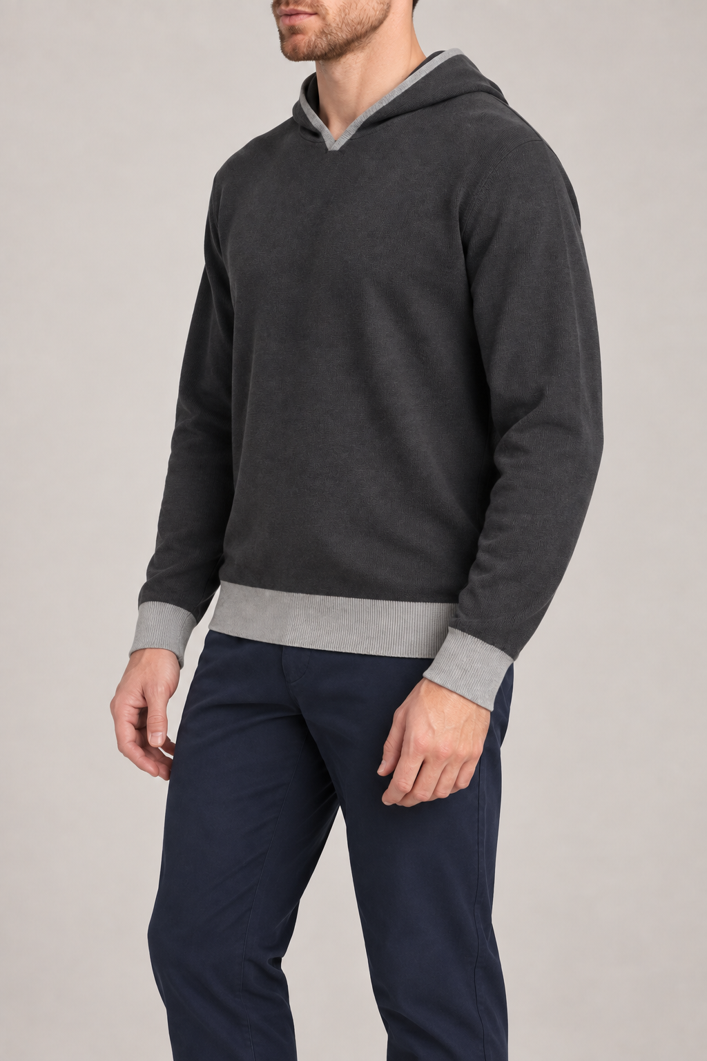 Three-quarter view showing the long sleeves and contrasting cuffs of Off Hours Knit Hoodie in Charcoal with Grey Trim.