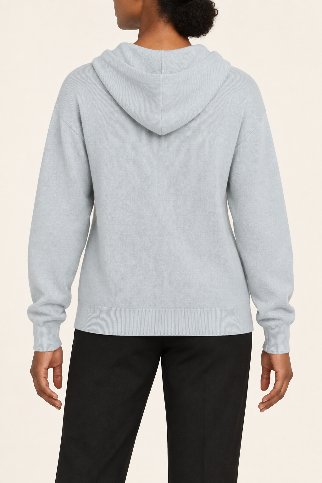 Rear view showing the plain blue back and draped hood of Quiet Ease Knit Hoodie in Powder.