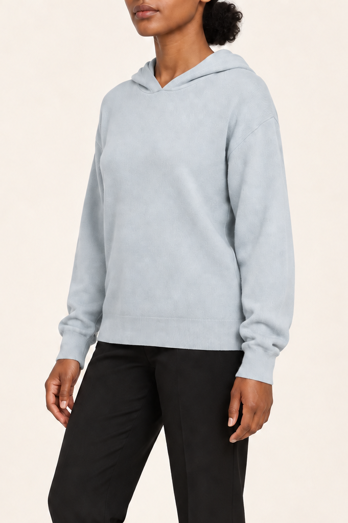 Three-quarter view showing the relaxed silhouette and matching edges of Quiet Ease Knit Hoodie in Powder.