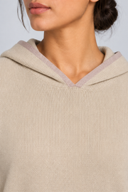 Detail view of the hood neckline and Taupe edging of Quiet Ease Knit Hoodie in Beige with Taupe Trim.