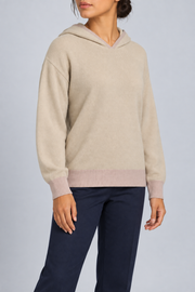 Three-quarter view showing the relaxed silhouette and contrasting cuffs of Quiet Ease Knit Hoodie in Beige with Taupe Trim.