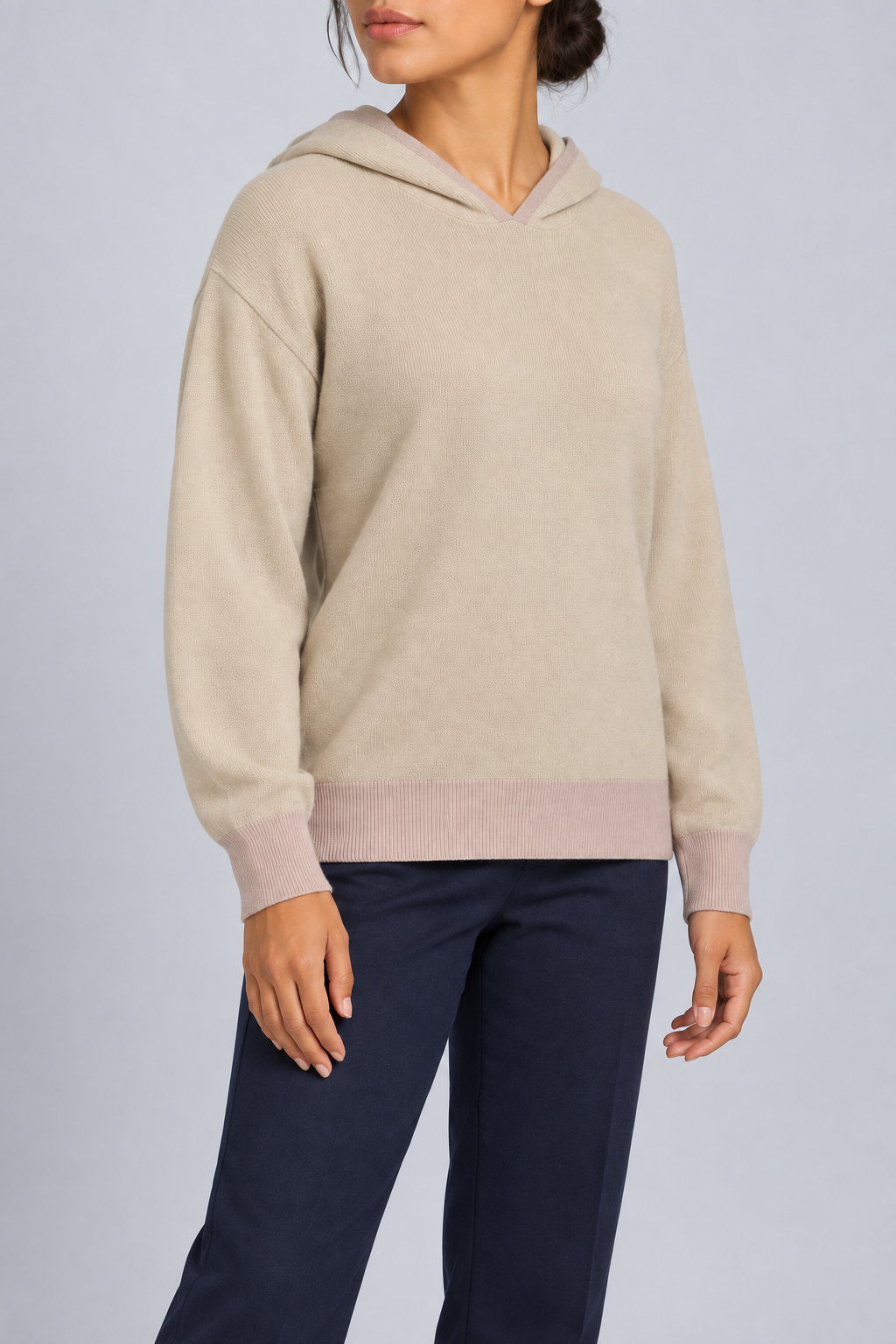 Three-quarter view showing the relaxed silhouette and contrasting cuffs of Quiet Ease Knit Hoodie in Beige with Taupe Trim.
