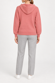 Rear view showing the plain coral back and draped hood of Quiet Ease Knit Hoodie in Coral.
