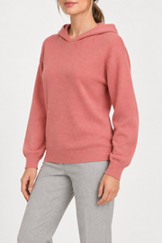 Three-quarter view showing the relaxed silhouette and matching edges of Quiet Ease Knit Hoodie in Coral.