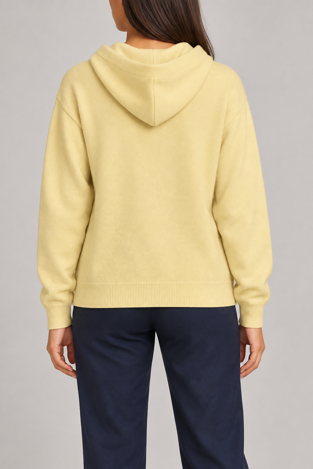 Rear view showing the plain yellow back and draped hood of Quiet Ease Knit Hoodie in Mellow.