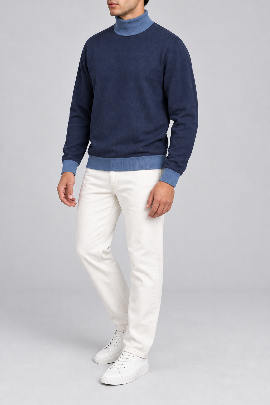 Three-quarter view showing the Navy silhouette and Denim hem of Still Season Turtleneck in Navy with Denim Trim.