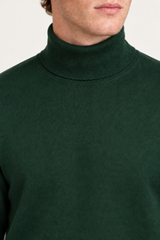 Close-up showing the Pine green turtle collar and fine knit texture of Still Season Turtleneck Sweater in Pine.