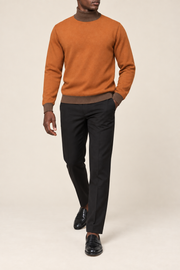 Walking view showing the Rust knit drape and Toffee cuffs of Still Season Turtleneck in Rust with Toffee Trim.