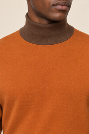 Close-up showing the Toffee turtle collar against the Rust knit of Still Season Turtleneck in Rust with Toffee Trim.