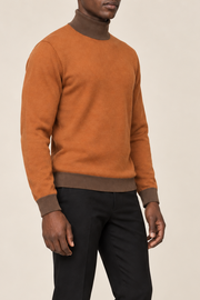 Three-quarter view showing the Rust silhouette and Toffee hem of Still Season Turtleneck in Rust with Toffee Trim.