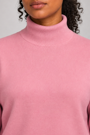 Close-up showing the Pink turtle collar and fine knit texture of Soft Horizon Turtleneck Sweater in Pink.
