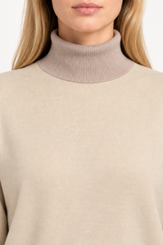 Close-up showing the Coco turtle collar against the Beige knit of Soft Horizon Turtleneck in Beige with Coco Trim.