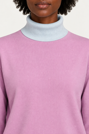 Close-up showing the Powder turtle collar against the Lilac knit of Soft Horizon Turtleneck in Lilac with Powder Trim.
