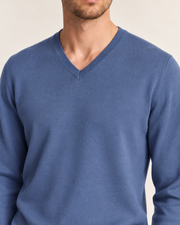 Close-up showing the Denim blue V neckline and fine knit texture of Quiet Angle V-Neck Sweater in Denim.