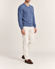 Three-quarter view showing the Denim blue classic fit and sleeves of Quiet Angle V-Neck Sweater in Denim.