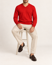 Seated view showing the Chili red knit drape of Quiet Angle V-Neck Sweater in Chili.