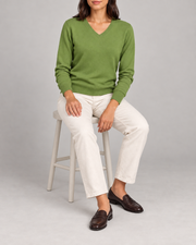 Seated view showing the Grass green knit drape of Soft Angle V-Neck Sweater in Grass.