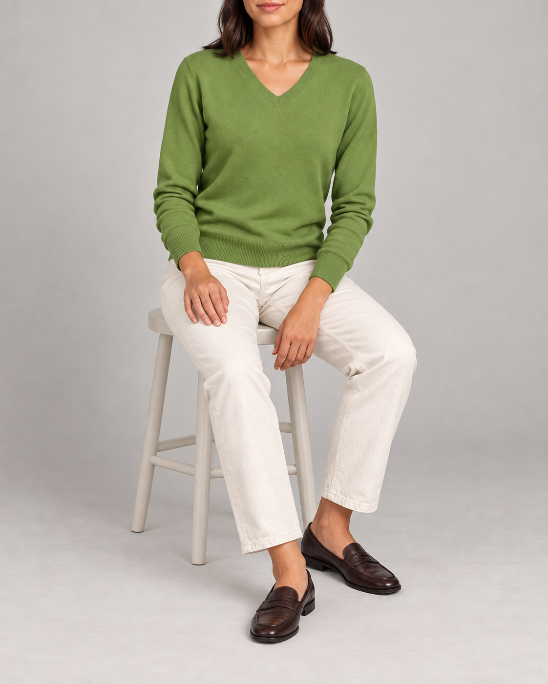 Seated view showing the Grass green knit drape of Soft Angle V-Neck Sweater in Grass.