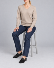 Seated view showing the Taupe knit drape of Soft Angle V-Neck Sweater in Taupe.