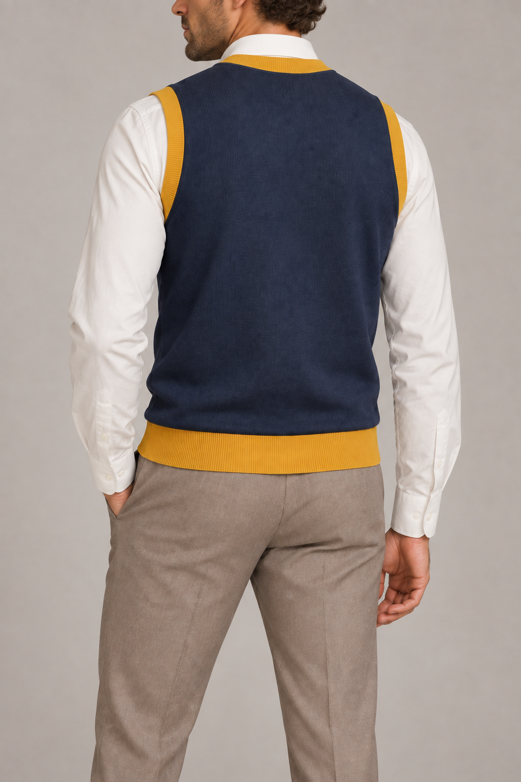 Quiet Layer V-Neck Vest in Navy with Mustard Trim, elegantly layered on a male model, rear three-quarter view.